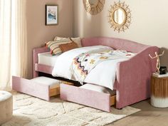 a pink bed with two drawers underneath it in a bedroom next to a rug and window