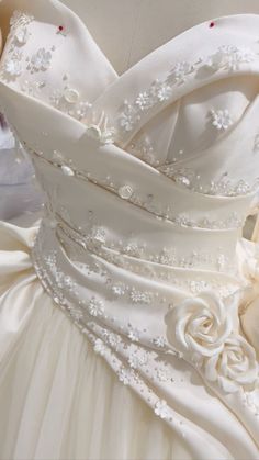 the back of a wedding dress with flowers on it