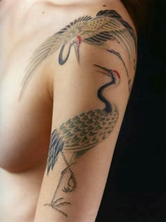 a woman's arm with a bird tattoo on it