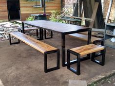 a wooden table and benches in front of a building