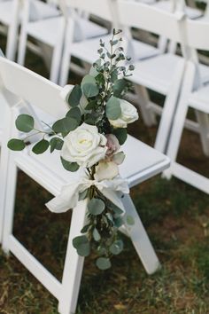 white chairs with flowers and greenery tied to them