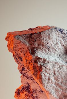 an orange and white rock with some dirt on it