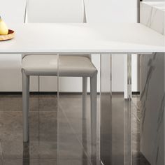 a white dining table with two chairs and an apple on the plate next to it