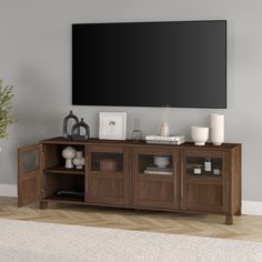 an entertainment center with a large flat screen tv mounted on it's sideboard