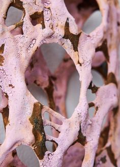 a close up view of some kind of art piece with pink and brown paint on it