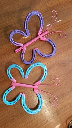 three paper clips are sitting on a table next to some scissors and eyeglasses