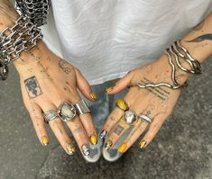 a person with tattoos and rings on their hands