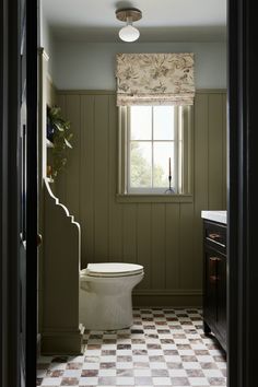 an open door leading to a bathroom with a checkered floor and walls in it