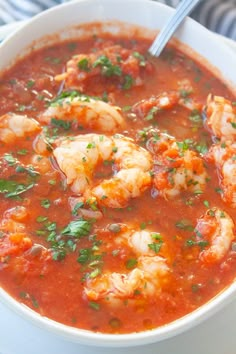 a white bowl filled with shrimp and tomato soup