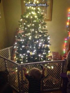 a little boy standing in front of a christmas tree