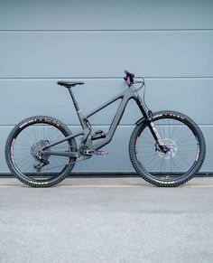 a bike parked in front of a garage door with its wheels still on the ground