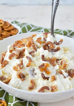 a white bowl filled with food next to pretzels