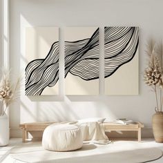 three black and white paintings hanging on the wall