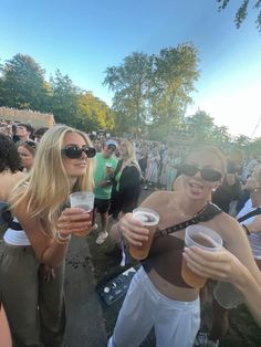 two women holding cups in their hands at an outdoor event