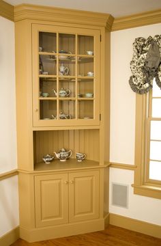 a china cabinet in the corner of a room