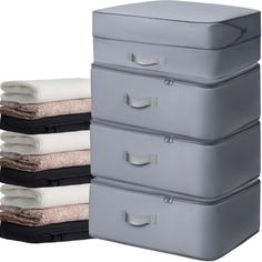 three storage boxes stacked on top of each other with towels folded in the bottom drawer