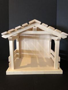 a wooden dollhouse with a roof made out of wood