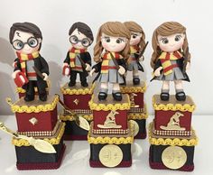 three harry potter figurines sitting on top of a red train with gold trimmings