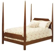 a bed with four posts and pillows on it