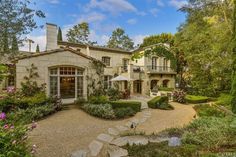 this is an image of a beautiful house in the woods with flowers and trees around it