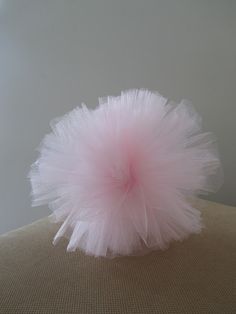 a pink fluffy ball sitting on top of a chair