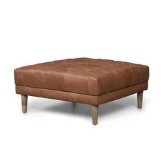 an ottoman with wooden legs and brown leather upholstered cushion on white background, side view