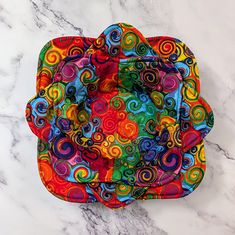 a multicolored flower on a marble countertop with the top rolled up to show it's colorful spirals