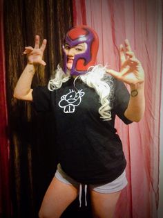 a woman with white hair wearing a purple mask and holding up two fingers in front of her face