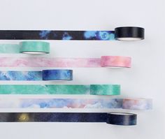 four rolls of washi tape are hanging on the wall