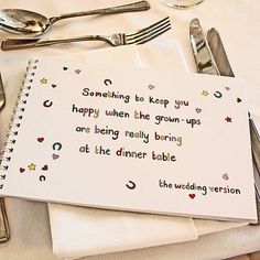 a table topped with silverware and napkins next to a notepad that says something to keep you happy when the grown up are being really boring at the dinner table