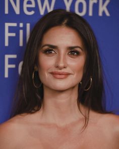 a close up of a person wearing large hoop earrings and a strapless bra top