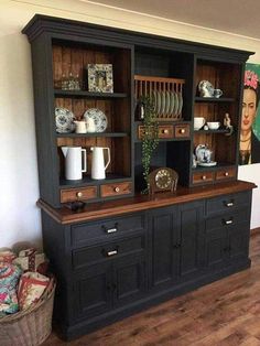 a black china cabinet with plates and cups on it