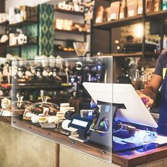 a man standing behind a counter with a laptop