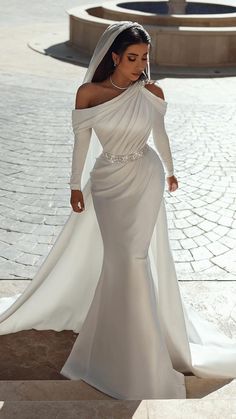 a woman in a wedding dress walking down the street