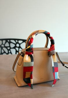 a handbag sitting on top of a table next to a chair