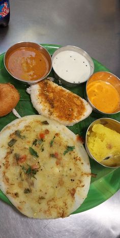 a green plate topped with different types of food on top of a metal countertop