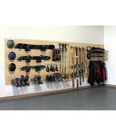 a wall mounted ski rack filled with lots of skis and snowboards on it