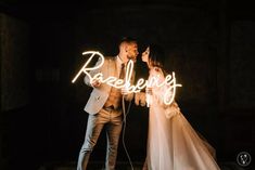 a bride and groom standing next to each other in front of a neon sign with the words reselency