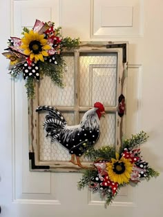 a rooster and sunflower wreath on the front door of a house with an old window