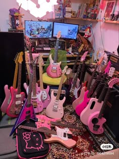 a room filled with lots of pink guitars and musical equipment on top of a rug