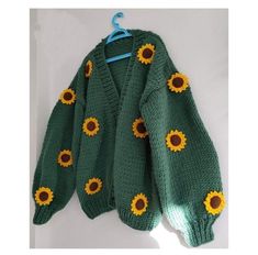 a green sweater with sunflowers on it