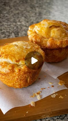 two pastries sitting on top of a wooden cutting board