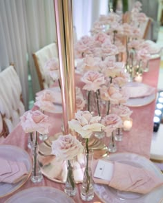 the table is set with pink flowers and place settings