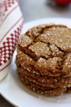 three cookies stacked on top of each other on a white plate next to a red and white towel