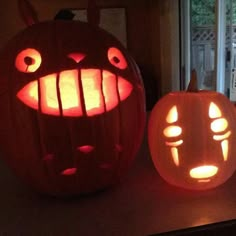 two pumpkins with faces carved into them