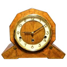 an antique wooden clock with white numbers on the face and hands, in front of a white background