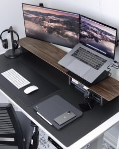 a desk with two laptops and a phone on it next to a computer monitor