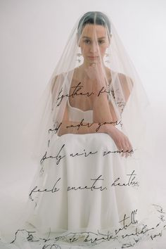 a woman wearing a wedding veil with writing on it