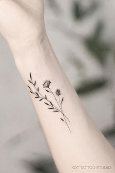 a small flower tattoo on the wrist