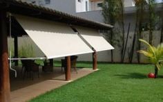 an outdoor area with grass, tables and umbrellas on the side of the building